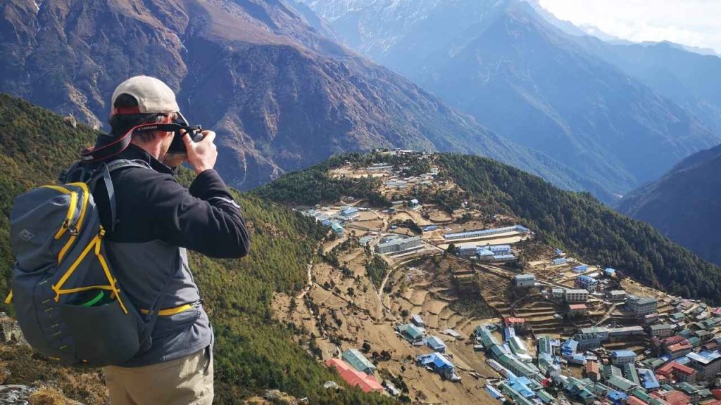Trekker photographing Namche Bazaar in the Everest region.