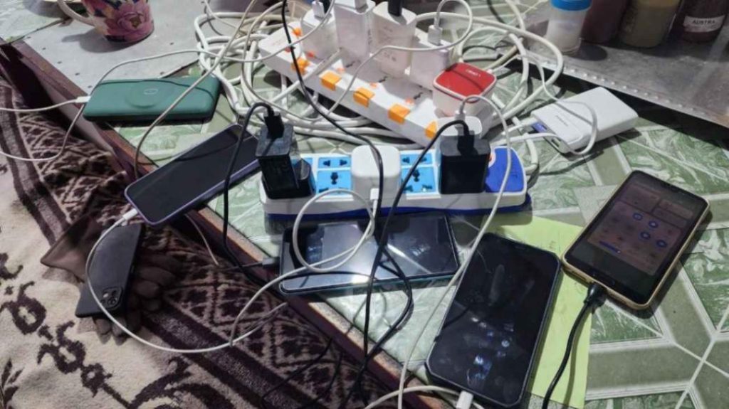 Phones and power banks charging in a teahouse, showing Annapurna Base Camp trek WiFi and electricity options